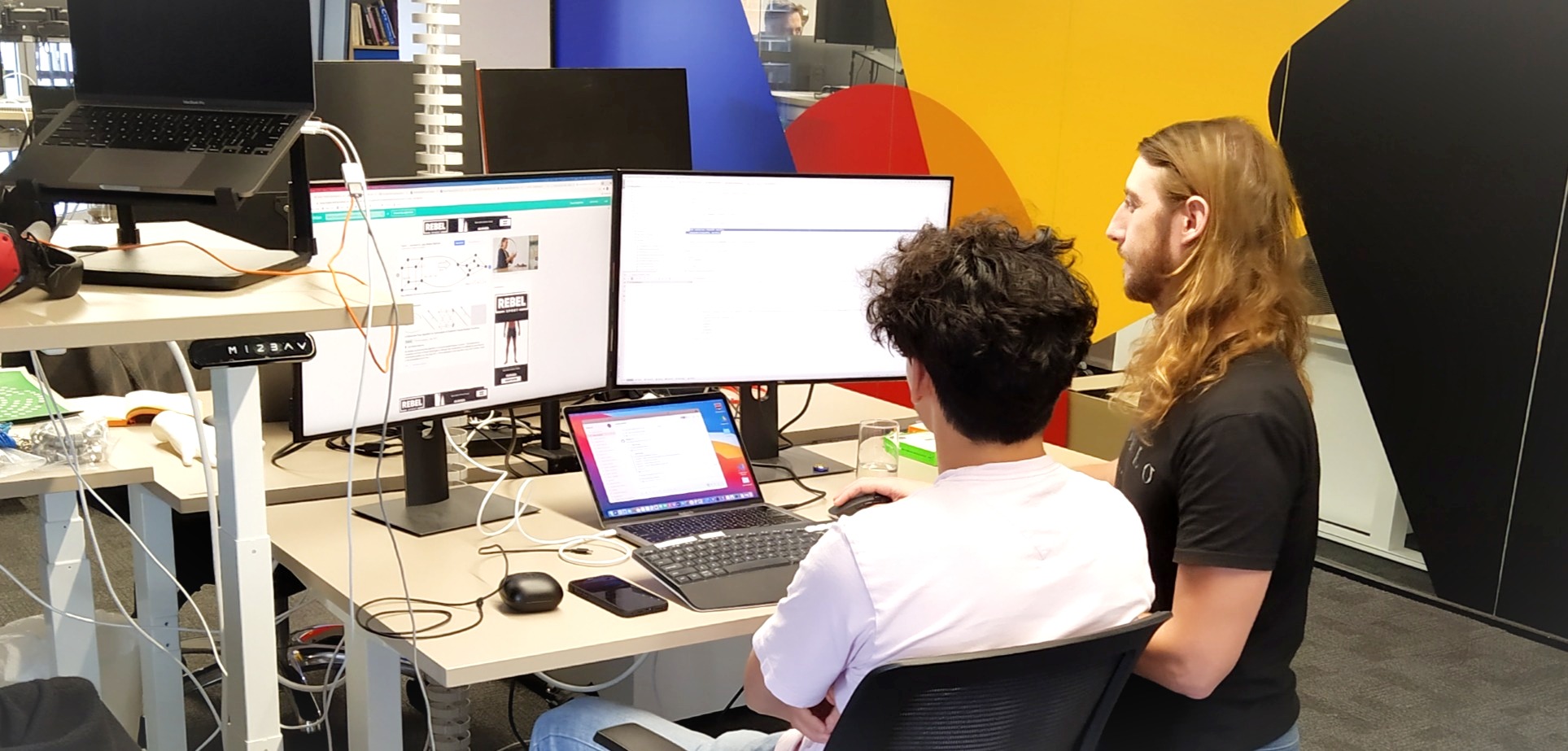 Two ZOZO developers collaborating in front of computer screens